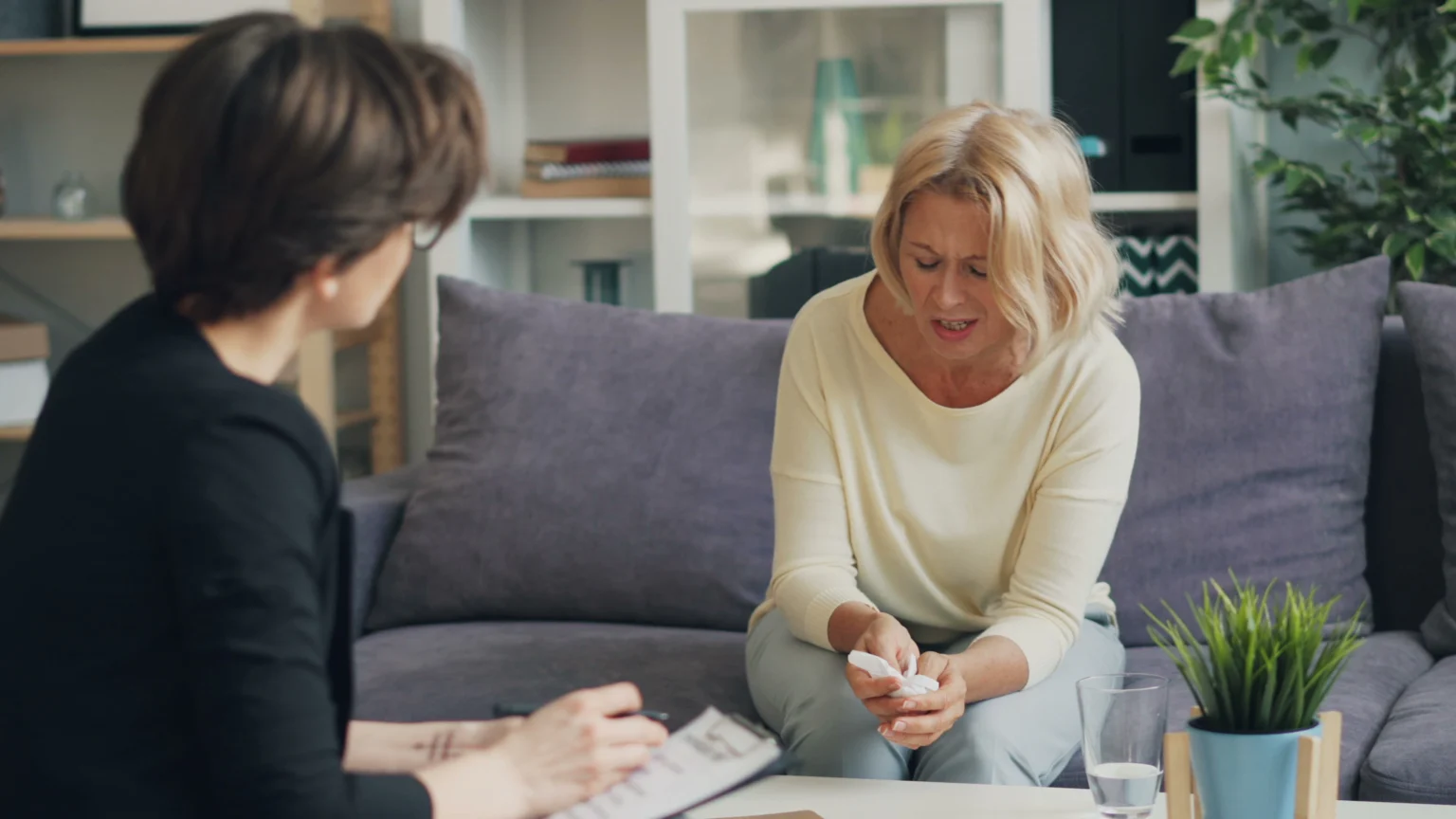 Two women discussing care needs while seated together at home