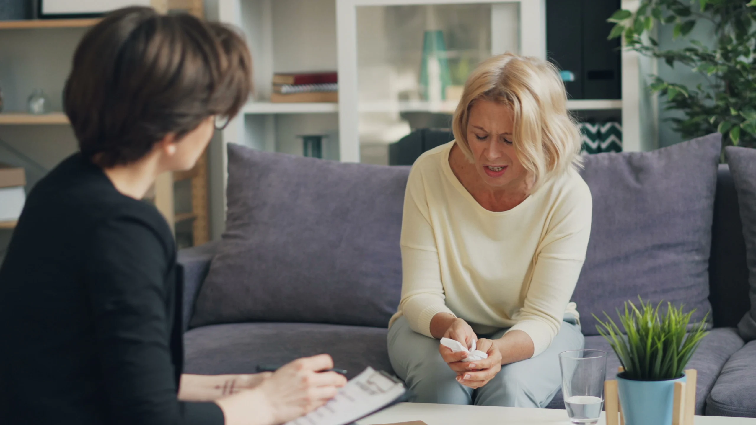 Two women discussing care needs while seated together at home